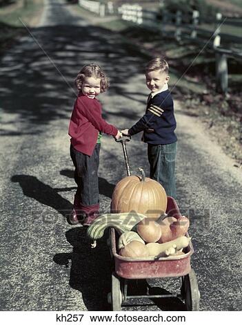 1950S 2 Kids In Blue Jeans Pulling Red Wagon Full Of Pumpkins Gourds Harvest Autumn Girl Red Sweater Boy Blue Varsity View Large Photo Image Stock Photo - 1950S 2 Kids In Blue Jeans Pulling Red Wagon Full Of Pumpkins Gourds Harvest Autumn Girl Red Sweater Boy Blue Varsity . Fotosearch