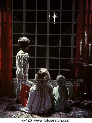 1950S 3 Children 2 Boys 2 Girl Pajamas Look Out French Doors To Star Bethlehem Christmas Eve Boy Holds Stocking Studio View Large Photo Image Stock Photography - 1950S 3 Children 2 Boys 2 Girl Pajamas Look Out French Doors To Star Bethlehem Christmas Eve Boy Holds Stocking Studio . Fotosearch