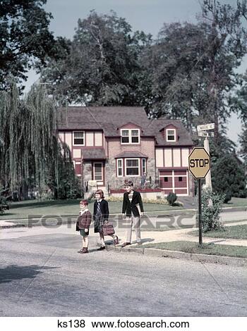 1950S 3 Kids 2 Boys 1 Girl Crossing The Street Residential Suburban By Yellow Stop Sign Carry Book Bags View Large Photo Image Stock Photo - 1950S 3 Kids 2 Boys 1 Girl Crossing The Street Residential Suburban By Yellow Stop Sign Carry Book Bags . Fotosearch