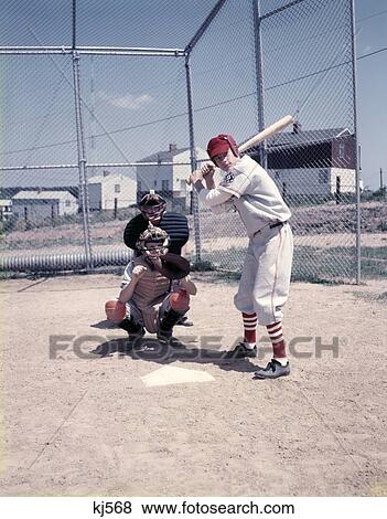 Stock Photo - 1950S 3 Kids Play Little League Baseball At Bat Home Plate Batter Catcher Umpire Sand Lot Fence Uniforms Sport. Fotosearch