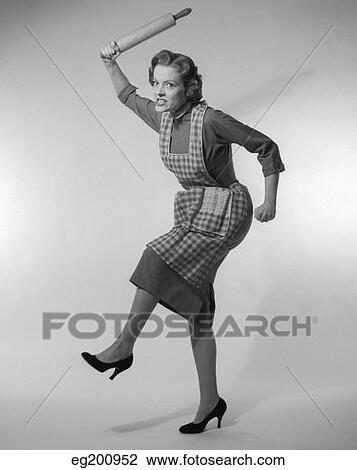 1950S Angry Housewife In Apron Wielding Rolling Pin Over Her Head View Large Photo Image Stock Image - 1950S Angry Housewife In Apron Wielding Rolling Pin Over Her Head. Fotosearch