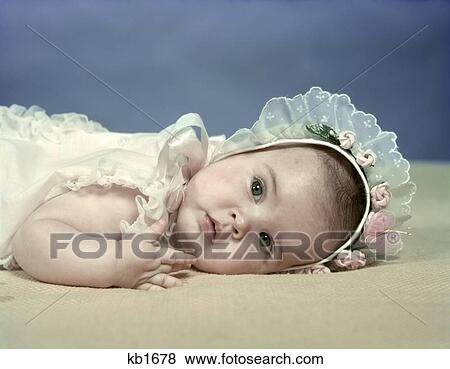 1950S Baby Girl Lying On Beige Blanket Wearing Baby Bonnet With Lace And Pink Rosebud Trim Spring Season View Large Photo Image Stock Photo - 1950S Baby Girl Lying On Beige Blanket Wearing Baby Bonnet With Lace And Pink Rosebud Trim Spring Season. Fotosearch