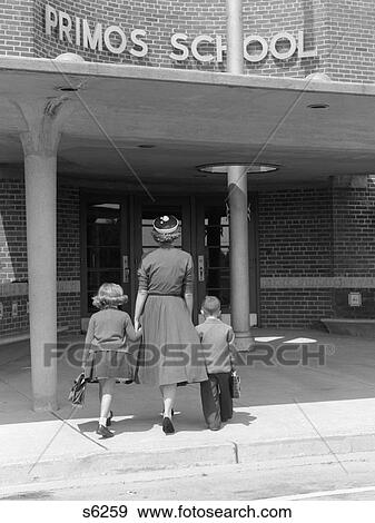 1950S Back View Of Mother Holding Hands Of Son & Daughter Walking Them Into School View Large Photo Image Stock Photo - 1950S Back View Of Mother Holding Hands Of Son & Daughter Walking Them Into School . Fotosearch