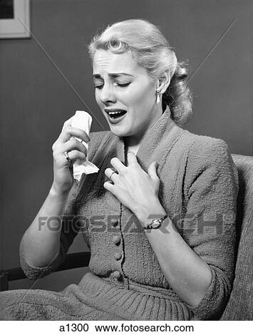 Stock Image - 1950S Blonde Woman In Chair About To Sneeze Sneezing Handerchief In One Hand Cold Flu Allergy Cough Coughing . Fotosearch