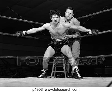1950S Boxer In Ring With Coach Trainer Holding Him Back Arms Stretched Holding Ropes On Either Side Determined Aggressive View Large Photo Image Stock Image - 1950S Boxer In Ring With Coach Trainer Holding Him Back Arms Stretched Holding Ropes On Either Side Determined Aggressive. Fotosearch