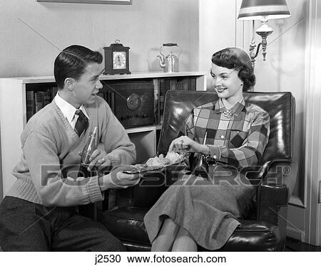 1950S Boy Girl Young Teen Couple Dating Sitting In Chair Drinking Cokes Eating Potato Chips View Large Photo Image Stock Image - 1950S Boy Girl Young Teen Couple Dating Sitting In Chair Drinking Cokes Eating Potato Chips . Fotosearch