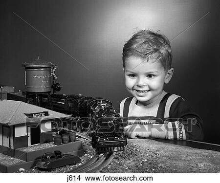 1950S Boy Smiling Happy Playing With Model Trains With A Toy Railroad Station And Water Tower View Large Photo Image Picture - 1950S Boy Smiling Happy Playing With Model Trains With A Toy Railroad Station And Water Tower. Fotosearch