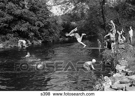 1950S Boys Girls Group Swimming In Creek Stream Pond Summer Fun Jump Splash Dive Retro Vintage Swim Swimming Hole View Large Photo Image Stock Photo - 1950S Boys Girls Group Swimming In Creek Stream Pond Summer Fun Jump Splash Dive Retro Vintage Swim Swimming Hole . Fotosearch