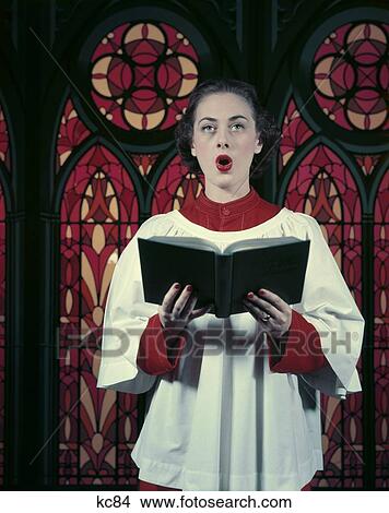 1950S Brunette Woman Red White Choir Robes Singing Holding Music Hymn Book Stained Glass Background Praise Song View Large Photo Image Picture - 1950S Brunette Woman Red White Choir Robes Singing Holding Music Hymn Book Stained Glass Background Praise Song . Fotosearch
