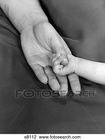 Stock Image - 1950S Close-Up Of Baby Holding Mother'S Thumb . Fotosearch