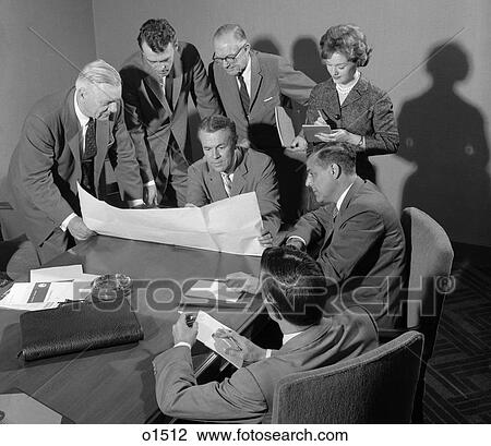 Stock Image - 1950S Conference Room With Men Looking Over Papers While Secretary Takes Notes . Fotosearch
