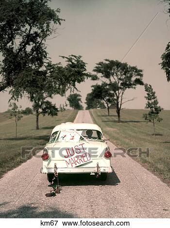 1950S Couple Bride And Groom Riding In Ford Sedan On Beginning Of Long Road Just Married Sign Americana Nostalgia View Large Photo Image Stock Photo - 1950S Couple Bride And Groom Riding In Ford Sedan On Beginning Of Long Road Just Married Sign Americana Nostalgia . Fotosearch