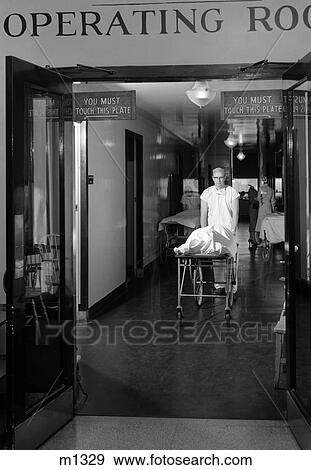 1950S Doctor Wheeling Patient Out Of Operating Room View Large Photo Image Stock Photo - 1950S Doctor Wheeling Patient Out Of Operating Room . Fotosearch