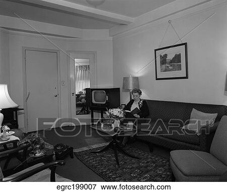 1950S Elderly Woman Sitting On Couch In Living Room Next To Tv View Large Photo Image Stock Photo - 1950S Elderly Woman Sitting On Couch In Living Room Next To Tv. Fotosearch
