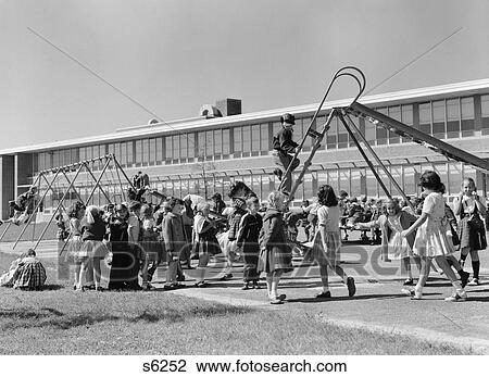 1950S Elementary School Playground At Recess With Children Playing On Slide & Swingset View Large Photo Image Stock Image - 1950S Elementary School Playground At Recess With Children Playing On Slide & Swingset . Fotosearch