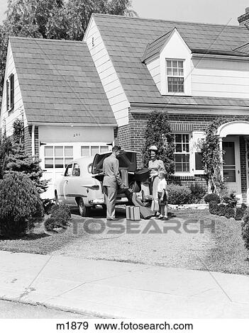 Stock Photo - 1950S Family Mother Father Son In Front Of Suburban House Loading Car Trunk With Luggage Suitcase Golf Bag Trip Vacation. Fotosearch