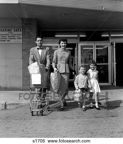 1950S Family Of 4 Walking Out Of Grocery Store Mother & Son Carrying Bags & Father Pushing Cart View Large Photo Image Stock Photography - 1950S Family Of 4 Walking Out Of Grocery Store Mother & Son Carrying Bags & Father Pushing Cart . Fotosearch