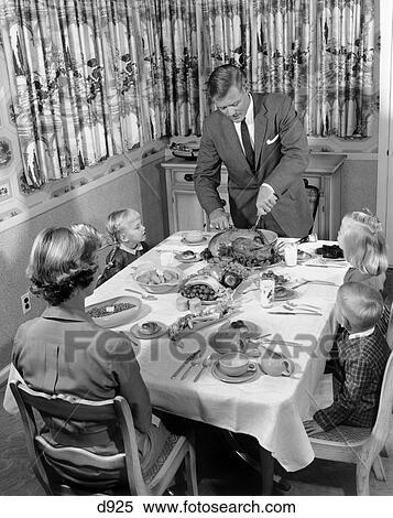 Stock Photography - 1950S Family Of 5 At Dining Room Table For Thanksgiving Dinner With Father Carving Turkey . Fotosearch