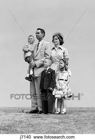 1950S Family Of Five Standing In A Tight Group They Are All Dressed Up The Father Is Holding The Smallest Boy View Large Photo Image Stock Image - 1950S Family Of Five Standing In A Tight Group They Are All Dressed Up The Father Is Holding The Smallest Boy. Fotosearch