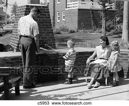 1950S Family On Bricked Backyard Patio Little Boy Cooking Hot Dog On Skewer View Large Photo Image Stock Image - 1950S Family On Bricked Backyard Patio Little Boy Cooking Hot Dog On Skewer . Fotosearch