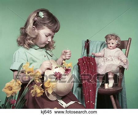 1950S Girl Child Sewing Flowers On Straw Hat Daffodils Baby Doll Toy High Chair Umbrella Spring Easter Bonnet View Large Photo Image Stock Photography - 1950S Girl Child Sewing Flowers On Straw Hat Daffodils Baby Doll Toy High Chair Umbrella Spring Easter Bonnet. Fotosearch