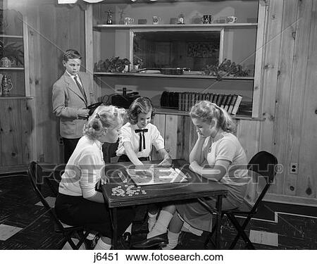 1950S Girls Playing Scrabble In Rec Room With Boy Changing Records View Large Photo Image Stock Image - 1950S Girls Playing Scrabble In Rec Room With Boy Changing Records . Fotosearch