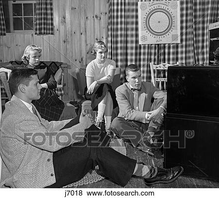 1950S Group Of Teens Boys Girls Watching Console Television Knotty Pine Rec Room View Large Photo Image Stock Photo - 1950S Group Of Teens Boys Girls Watching Console Television Knotty Pine Rec Room . Fotosearch