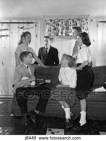 1950S Group Six Teenagers Three Boys Three Girls Sitting On Couch Den Rec Room Boy Playing Ukelele Others Singing Song Music View Large Photo Image Stock Photo - 1950S Group Six Teenagers Three Boys Three Girls Sitting On Couch Den Rec Room Boy Playing Ukelele Others Singing Song Music . Fotosearch