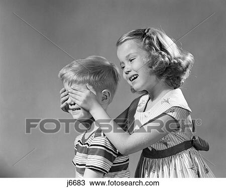 Stock Image - 1950S Guess Who Girl Hold Hands Over Boys Eyes Blind Game Teasing Playing . Fotosearch