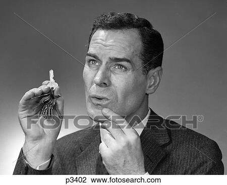 1950S Head Shot Of Man Holding Pair Of Keys Pointing To Chin Indoor Memory Remember Face Expression Thinking View Large Photo Image Stock Image - 1950S Head Shot Of Man Holding Pair Of Keys Pointing To Chin Indoor Memory Remember Face Expression Thinking . Fotosearch