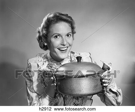 1950S Housewife Wearing Apron Proudly Holding Up A Cooking Pot View Large Photo Image Stock Image - 1950S Housewife Wearing Apron Proudly Holding Up A Cooking Pot . Fotosearch