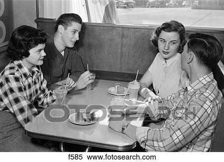 1950S Juv. Teen Couples At Table With Sodas And Saucers Of Crackers Wearing Plaid And Solid Color Shirts Talking Inside View Large Photo Image Stock Photography - 1950S Juv. Teen Couples At Table With Sodas And Saucers Of Crackers Wearing Plaid And Solid Color Shirts Talking Inside. Fotosearch