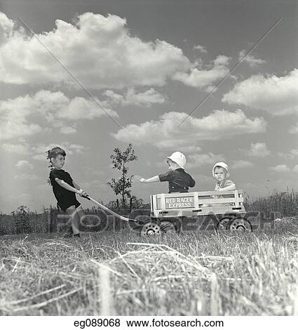 1950S Little Boy Pulling Red Racer Express Toy Wagon With Two Toddlers Riding Inside View Large Photo Image Stock Photo - 1950S Little Boy Pulling Red Racer Express Toy Wagon With Two Toddlers Riding Inside. Fotosearch