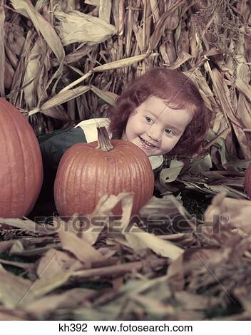 1950S Little Girl With Red Hair Hiding Behind Pumpkin Smiling Laughing Dried Corn Stalk Harvest Autumn Cute Halloween View Large Photo Image Stock Image - 1950S Little Girl With Red Hair Hiding Behind Pumpkin Smiling Laughing Dried Corn Stalk Harvest Autumn Cute Halloween. Fotosearch