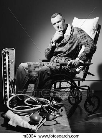 Picture - 1950S Man In Robe Seated In Wheelchair In Moody Dark Setting With Blood Pressure Cuff & Stethoscope In Foreground. Fotosearch