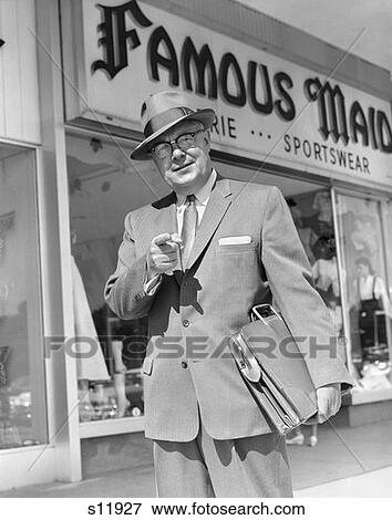 1950S Man Pointing To Camera Holding Briefcase Under Arm In Front Of Sports Wear Store Sell Suit Tie Hat Businessman View Large Photo Image Stock Photo - 1950S Man Pointing To Camera Holding Briefcase Under Arm In Front Of Sports Wear Store Sell Suit Tie Hat Businessman. Fotosearch