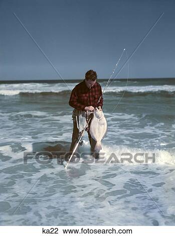 1950S Man Red Black Checked Shirt Stand In Surf Removing Flounder From Hook Catch Surf Casting Sport Fishing Ocean View Large Photo Image Stock Image - 1950S Man Red Black Checked Shirt Stand In Surf Removing Flounder From Hook Catch Surf Casting Sport Fishing Ocean. Fotosearch
