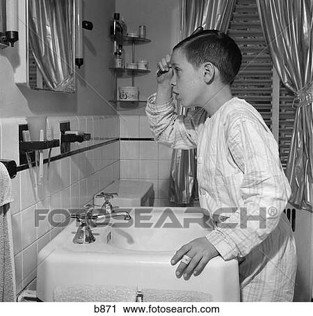 Banco de Imagem - 1950s, menino, penteando cabelo, olhando dentro, pia banheiro, espelho. Fotosearch