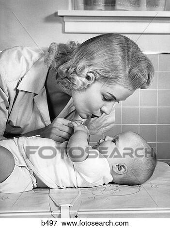 1950S Mother Woman Bending Over Baby Lying On Layette Holding Hands Talking Tile Walls Window Sill View Large Photo Image Stock Photo - 1950S Mother Woman Bending Over Baby Lying On Layette Holding Hands Talking Tile Walls Window Sill . Fotosearch