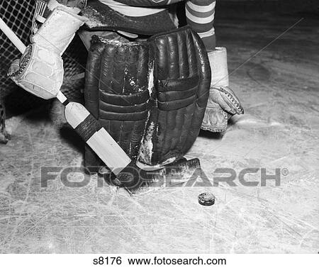 1950S Padded Goalie Shown Waist-Down Holding Stick With Puck In Front Of Him View Large Photo Image Stock Photograph - 1950S Padded Goalie Shown Waist-Down Holding Stick With Puck In Front Of Him . Fotosearch