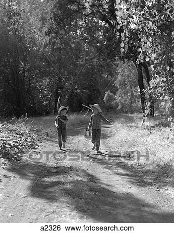 1950S Pair Of Boys In Dungarees Plaid Shirts & Straw Hats Walking Down Dirt Road Carrying Mock Fishing Poles & Can Of Bait View Large Photo Image Stock Photograph - 1950S Pair Of Boys In Dungarees Plaid Shirts & Straw Hats Walking Down Dirt Road Carrying Mock Fishing Poles & Can Of Bait. Fotosearch