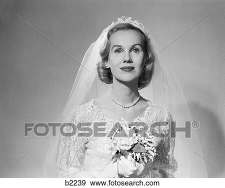 1950S Portrait Of Woman Bride Wearing White Wedding Dress Veil And String Of Pearls Holding A Bouquet Of Flowers View Large Photo Image Stock Photo - 1950S Portrait Of Woman Bride Wearing White Wedding Dress Veil And String Of Pearls Holding A Bouquet Of Flowers . Fotosearch