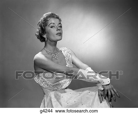 1950S Portrait Of Woman Dressed In Evening Gown With Beaded Cuffs & Jewelry Wearing A Haughty Facial Expression View Large Photo Image Picture - 1950S Portrait Of Woman Dressed In Evening Gown With Beaded Cuffs & Jewelry Wearing A Haughty Facial Expression . Fotosearch