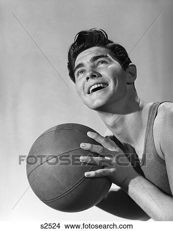 1950S Portrait Teen Boy Man Smiling Looking Up Holding Basketball Player View Large Photo Image Picture - 1950S Portrait Teen Boy Man Smiling Looking Up Holding Basketball Player . Fotosearch