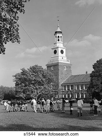 1950S School Football Team Practicing On Lawn In Front Of Stone Campus Building With Clock Tower View Large Photo Image Picture - 1950S School Football Team Practicing On Lawn In Front Of Stone Campus Building With Clock Tower . Fotosearch