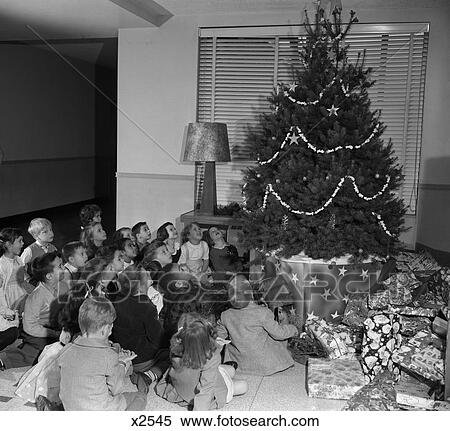 1950S Seated Group Of 20 Children Looking Up At Christmas Tree Decorated With Popcorn And Stars View Large Photo Image Stock Photography - 1950S Seated Group Of 20 Children Looking Up At Christmas Tree Decorated With Popcorn And Stars. Fotosearch