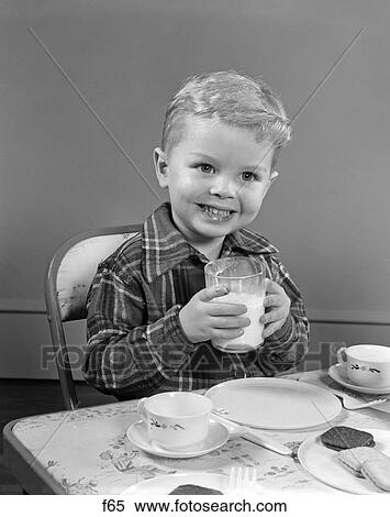 1950S Smiling Boy In Plaid Shirt Drinking Milk At Card Table Happy Nutrition Snack Cookies View Large Photo Image Stock Photography - 1950S Smiling Boy In Plaid Shirt Drinking Milk At Card Table Happy Nutrition Snack Cookies . Fotosearch