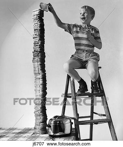 1950S Smiling Boy On Ladder Stacking Up Large Pile Tower Of Toast Toasted Bread View Large Photo Image Stock Photo - 1950S Smiling Boy On Ladder Stacking Up Large Pile Tower Of Toast Toasted Bread . Fotosearch