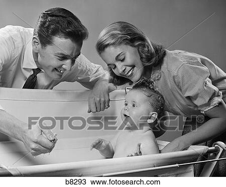1950S Smiling Parents Leaning Over Tub Bathing Baby View Large Photo Image Stock Image - 1950S Smiling Parents Leaning Over Tub Bathing Baby . Fotosearch