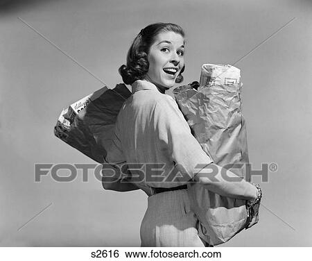 1950S Smiling Woman Carrying Grocery Bags Both Hands Looking Back Over Shoulder View Large Photo Image Stock Photograph - 1950S Smiling Woman Carrying Grocery Bags Both Hands Looking Back Over Shoulder . Fotosearch